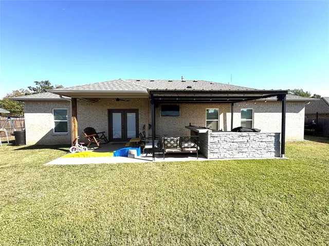 a view of a house with backyard and sitting area