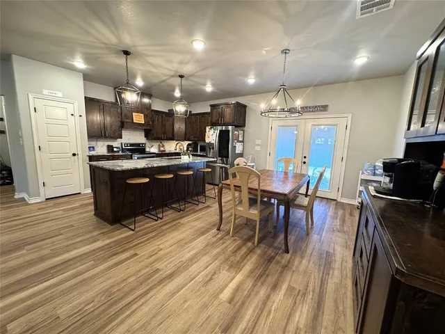 an open kitchen with wooden floor and stainless steel appliances