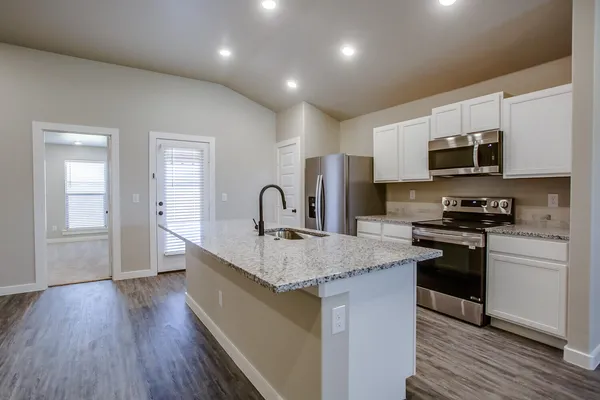 a view or kitchen counter top space with stainless steel appliances granite countertop wooden floor