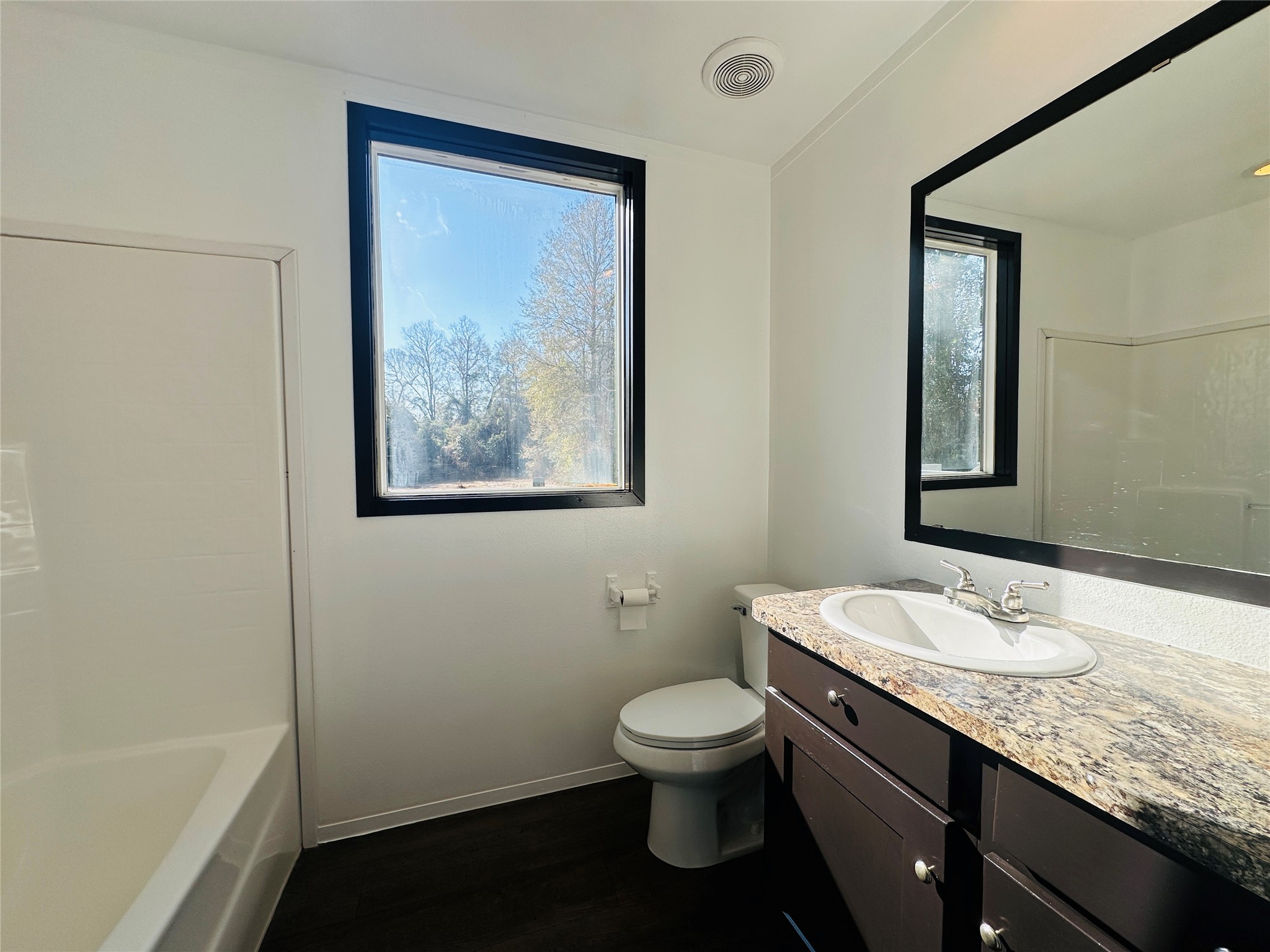 145 Campbell Street Shepherd, TX 77371 - Photo 13 of 36 a bathroom with a granite countertop toilet a sink and mirror