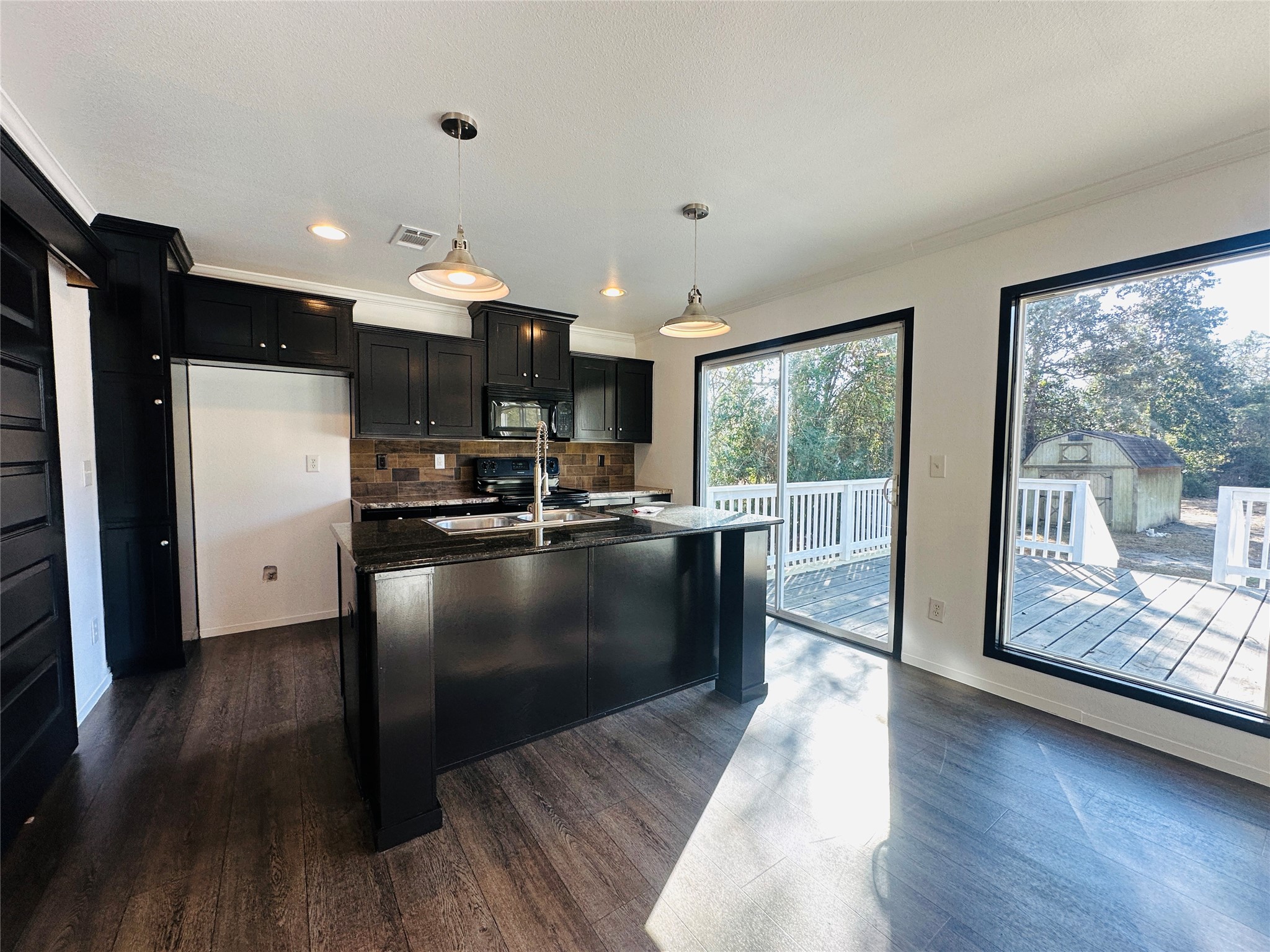 145 Campbell Street Shepherd, TX 77371 - Photo 6 of 36 a kitchen with stainless steel appliances granite countertop a refrigerator a sink dishwasher a stove and a dining table with wooden floor
