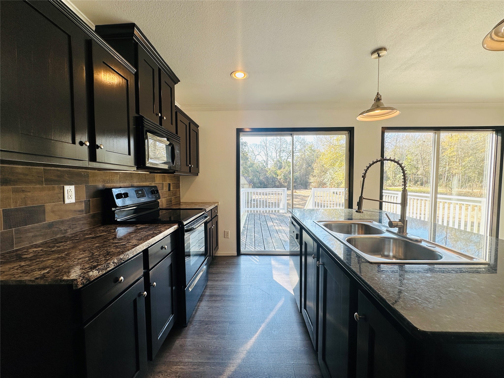 145 Campbell Street Shepherd, TX 77371 - Photo 7 of 36 a kitchen with stainless steel appliances granite countertop a sink a stove and a wooden cabinets
