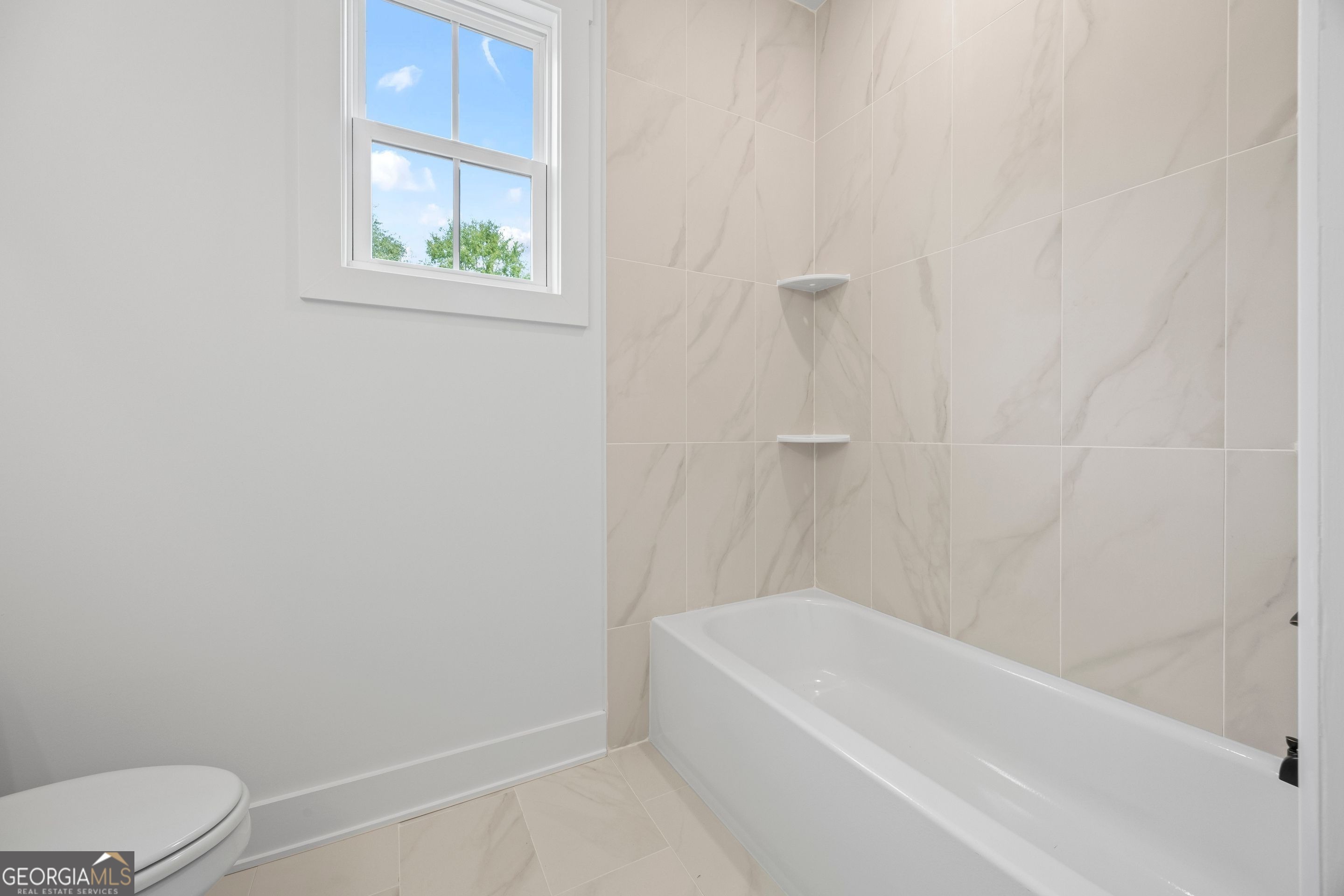 1231 John W Breedlove Road Monroe, GA 30656 - Photo 7 of 26 a bathroom with a bathtub and window