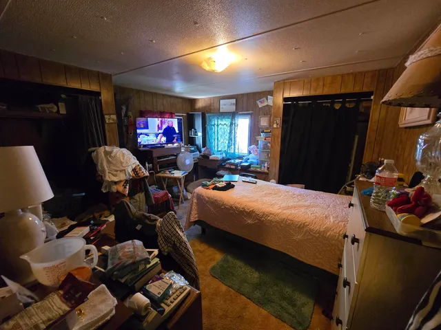 a bedroom with bed and a flat tv screen on dresser