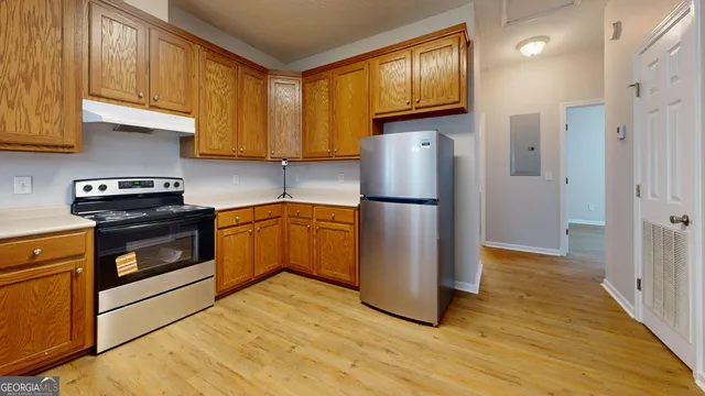 a kitchen with granite countertop wooden floors stainless steel appliances and a window