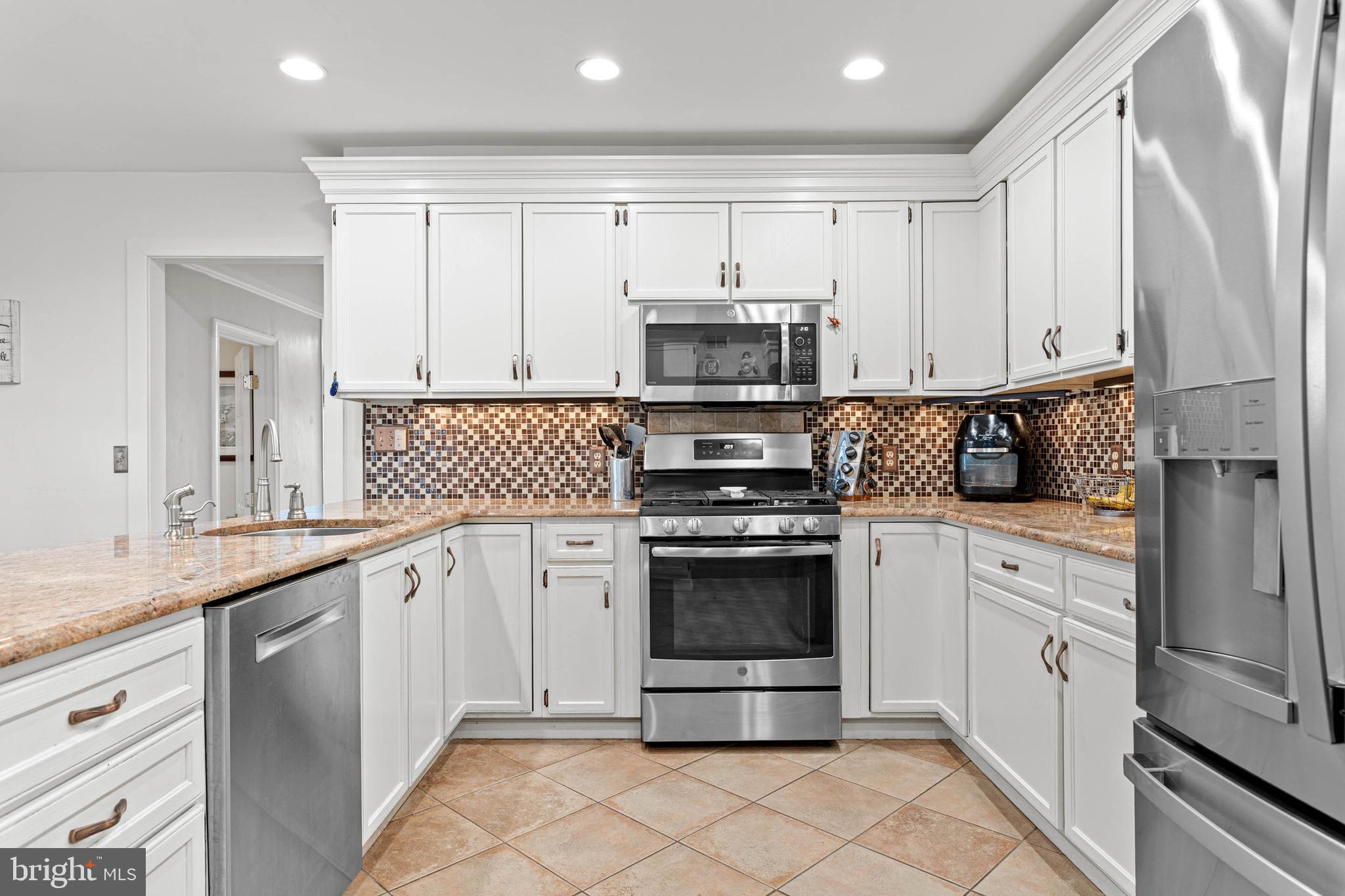 22 Russell Place Ambler, PA 19002 - Photo 24 of 65 a kitchen with stainless steel appliances granite countertop a stove a sink and a refrigerator