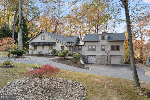 a view of a house with backyard and trees