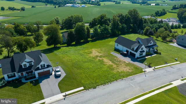 an aerial view of a house with backyard space and street view