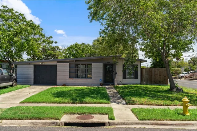 a front view of a house with a yard and a garage