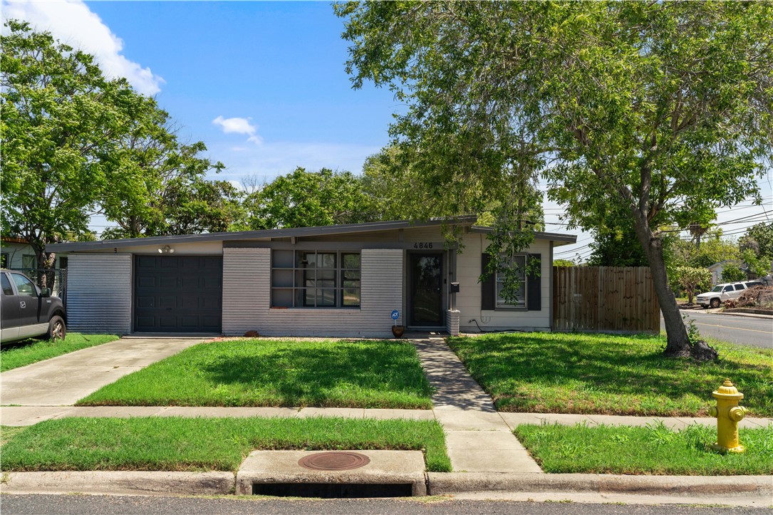 a front view of a house with a yard and a garage