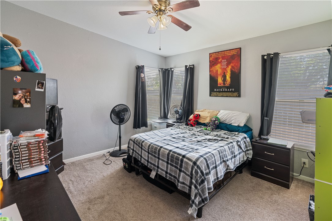 4846 Kasper Street Corpus Christi, TX 78415 - Photo 15 of 20 a bedroom with a bed and a chandelier