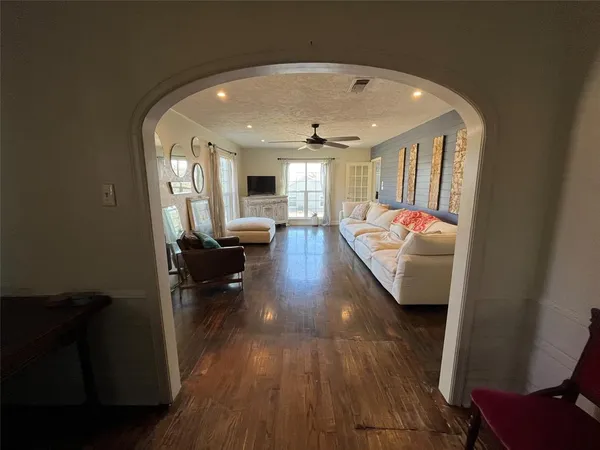 a view of a hallway to a livingroom with furniture