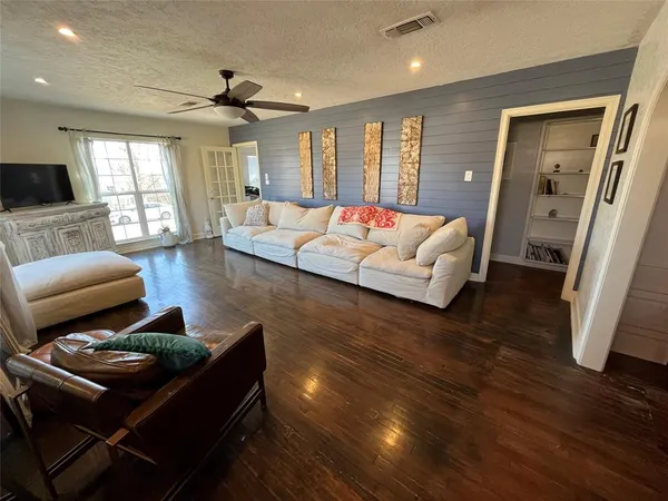 a living room with furniture and a wooden floor