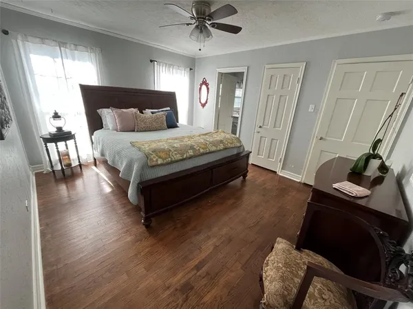 a bedroom with a bed and a dresser next to a window