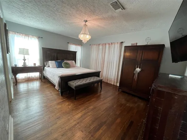 a spacious bedroom with a bed and a flat screen tv