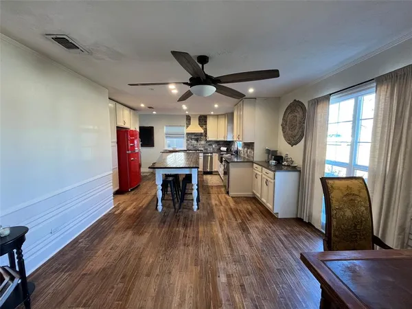 a kitchen with stainless steel appliances granite countertop a refrigerator a sink dishwasher a stove and white countertops with wooden floor