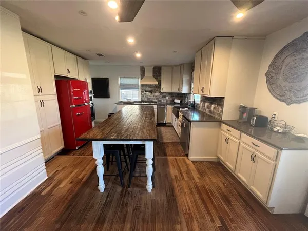 a kitchen with kitchen island granite countertop a sink a counter space appliances and cabinets