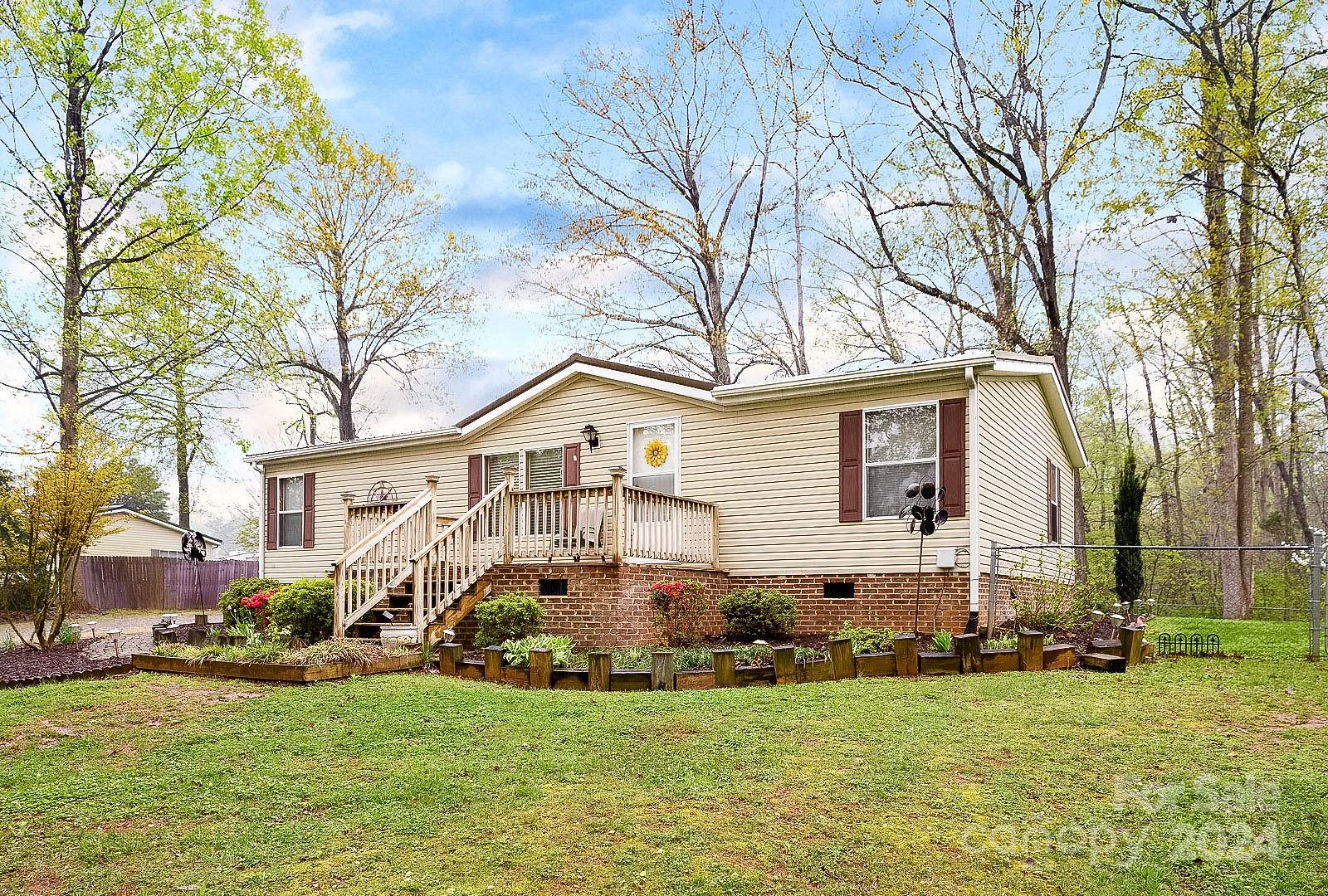 a view of a house with a big yard and large trees