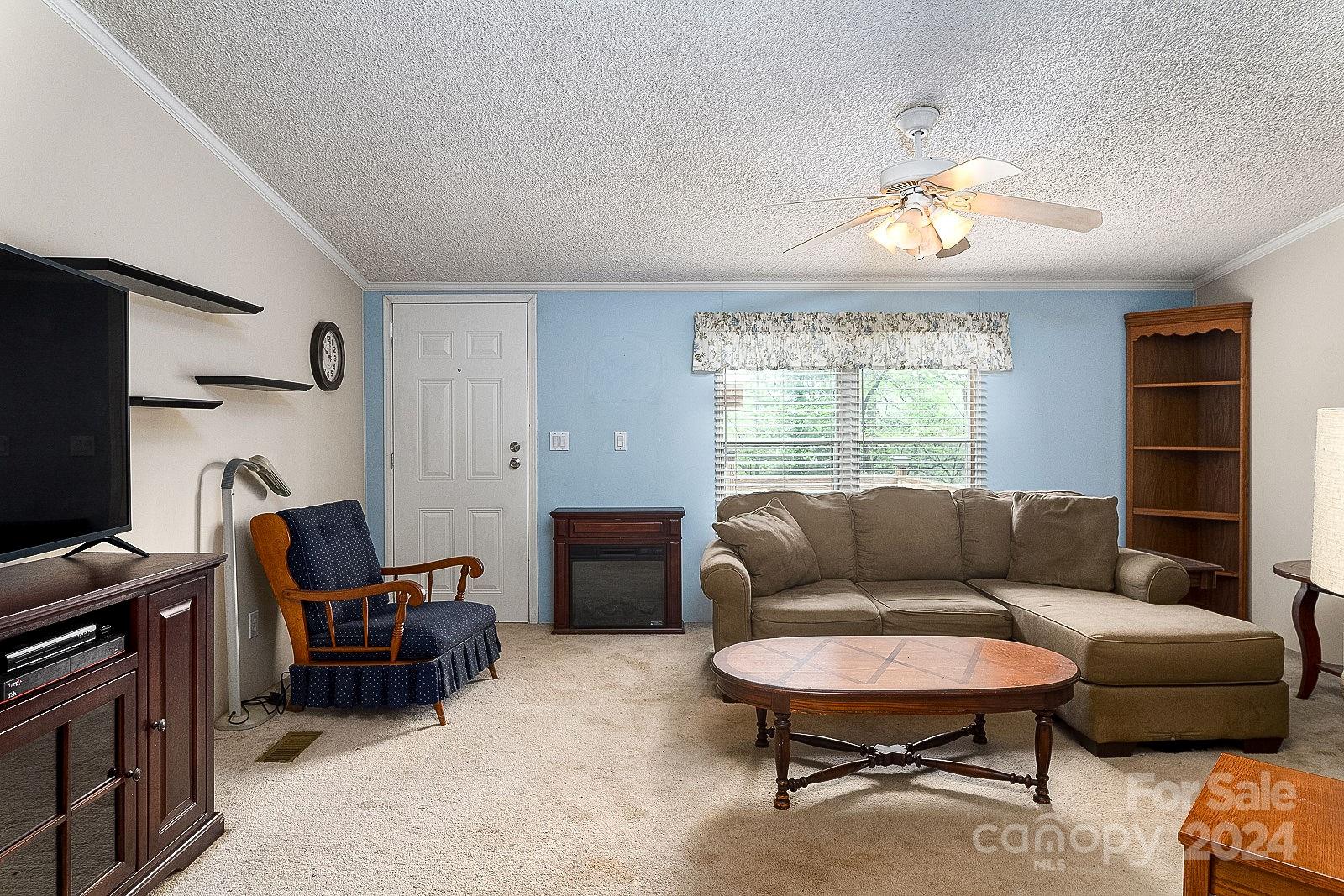740 Childers Road Cleveland, NC 27013 - Photo 4 of 24 a living room with furniture a flat screen tv and a window