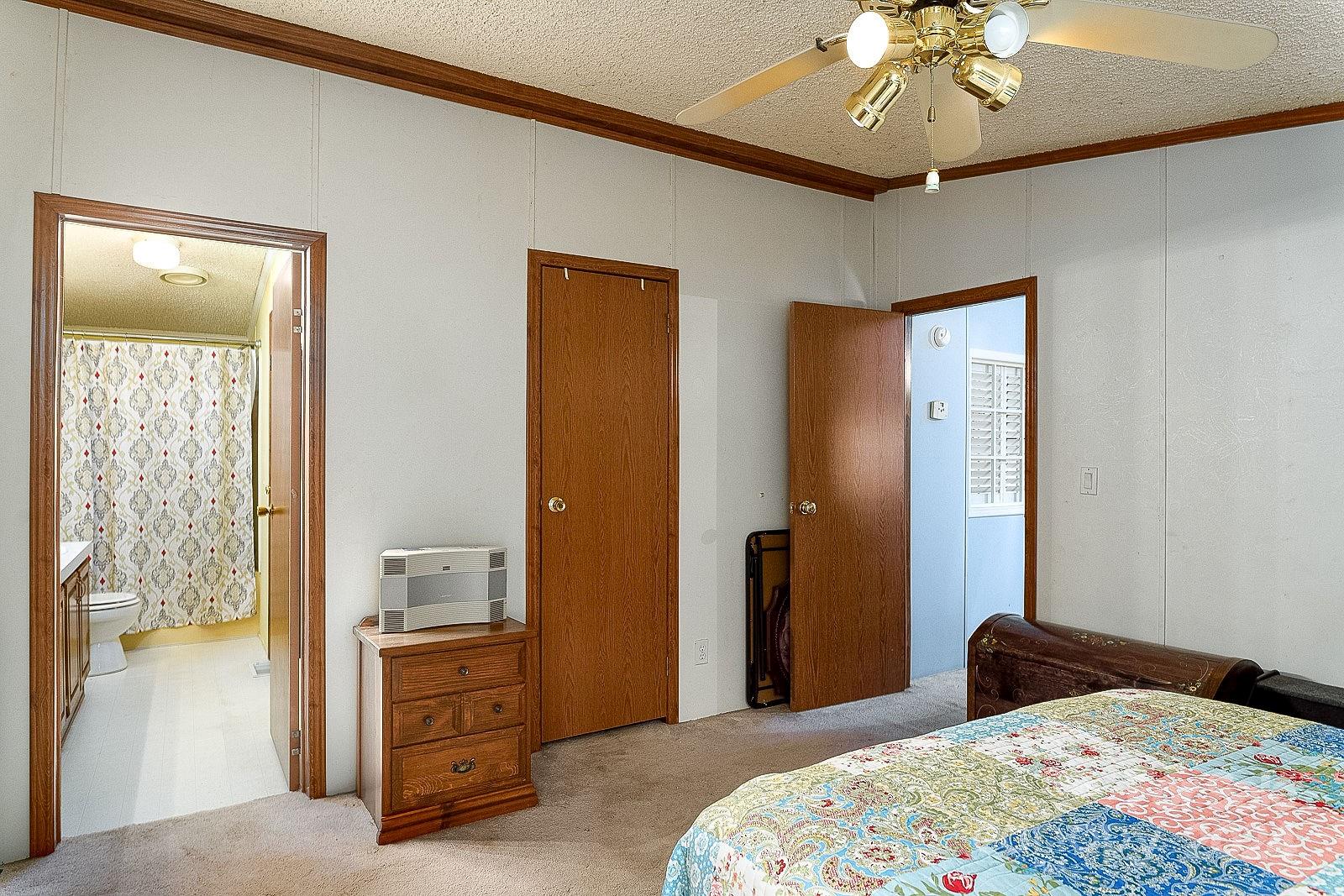 740 Childers Road Cleveland, NC 27013 - Photo 9 of 24 a bedroom with a bed and a chandelier