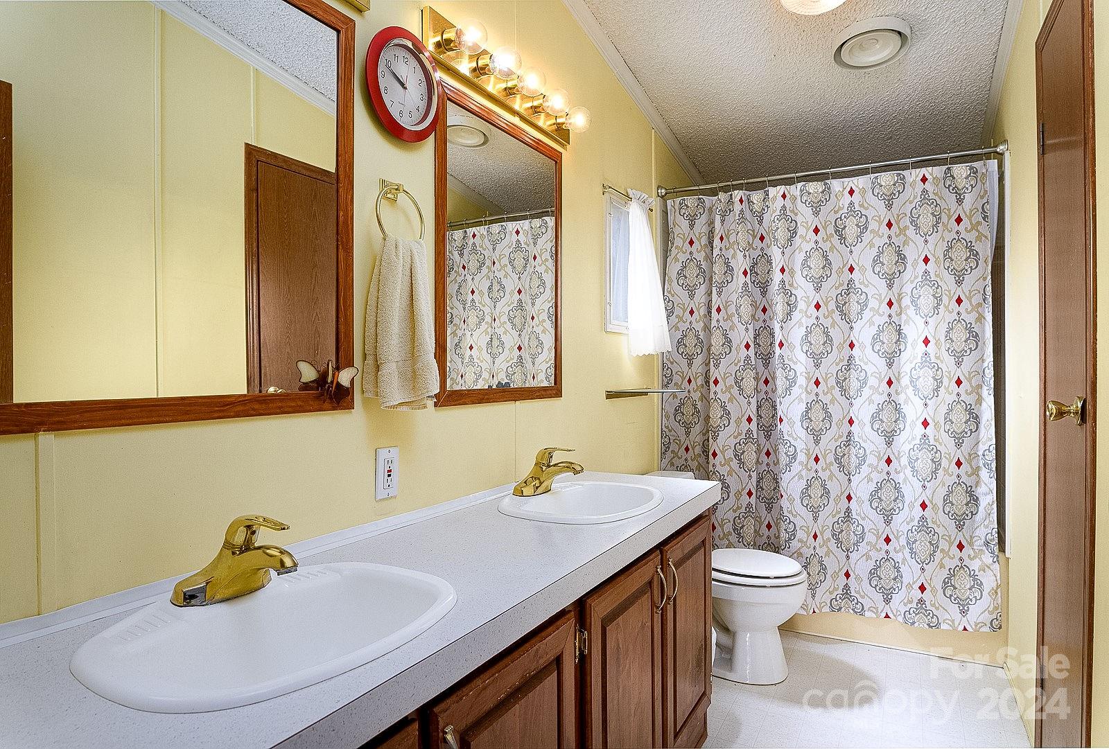 740 Childers Road Cleveland, NC 27013 - Photo 10 of 24 a bathroom with a sink a toilet and a mirror