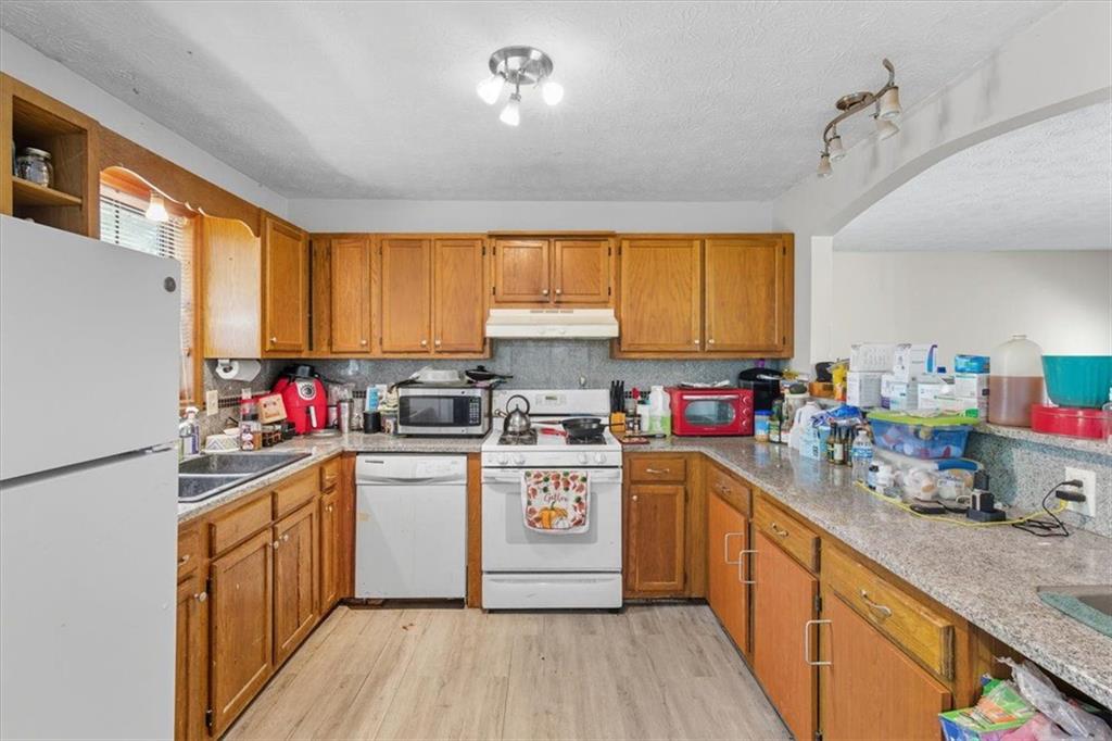 31 Powder Mill Drive Dallas, GA 30157 - Photo 7 of 41 a kitchen with a stove top oven a sink dishwasher and a refrigerator with wooden floor