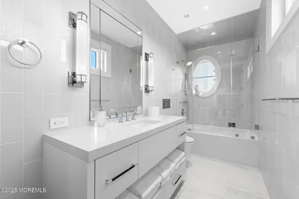 a living room with furniture a large window and wooden floor