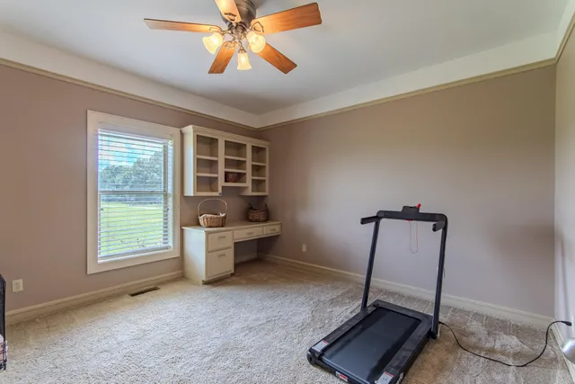 a view of a hallway with wooden floor and a bathroom