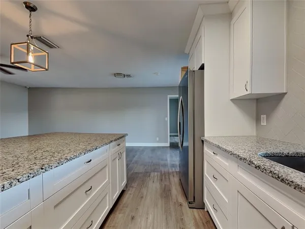 a kitchen with granite countertop a sink stove and refrigerator