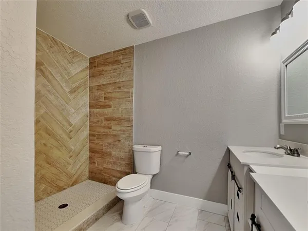 a bathroom with a shower toilet and sink