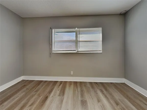 a view of a room that has wooden floor and cabinets