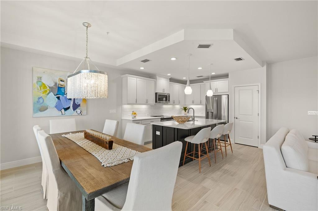 2647 Seychelles Circle, Unit 2203 Naples, FL 34112 - Photo 1 of 32 Dining area featuring baseboards, light wood-style floors, recessed lighting, and a chandelier