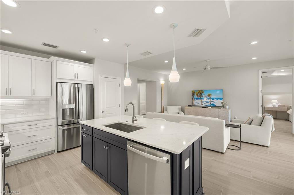2647 Seychelles Circle, Unit 2203 Naples, FL 34112 - Photo 32 of 32 a kitchen with a refrigerator a sink and cabinets