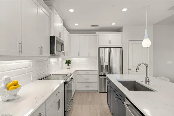 a kitchen with a refrigerator a sink and cabinets