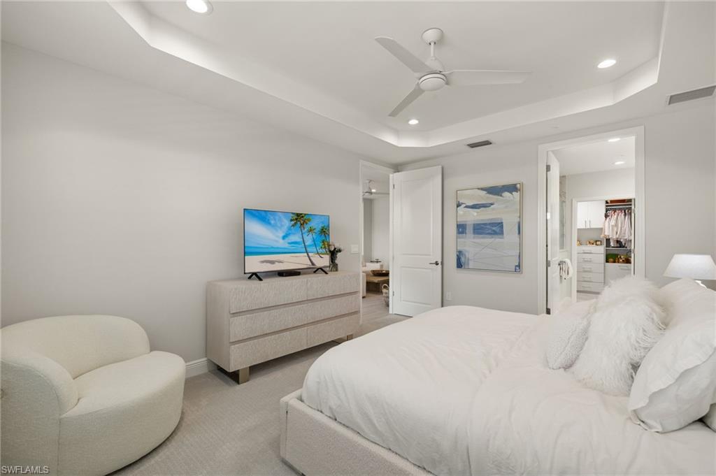 2647 Seychelles Circle, Unit 2203 Naples, FL 34112 - Photo 15 of 32 a bedroom with furniture and a chandelier