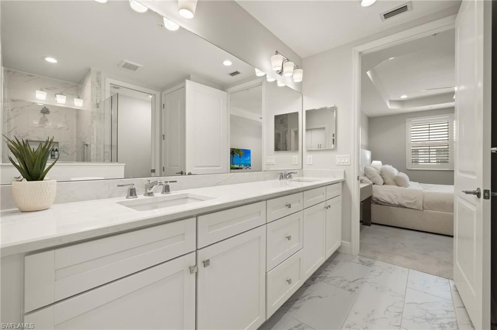 2647 Seychelles Circle, Unit 2203 Naples, FL 34112 - Photo 16 of 32 a bathroom with a double vanity sink and a mirror