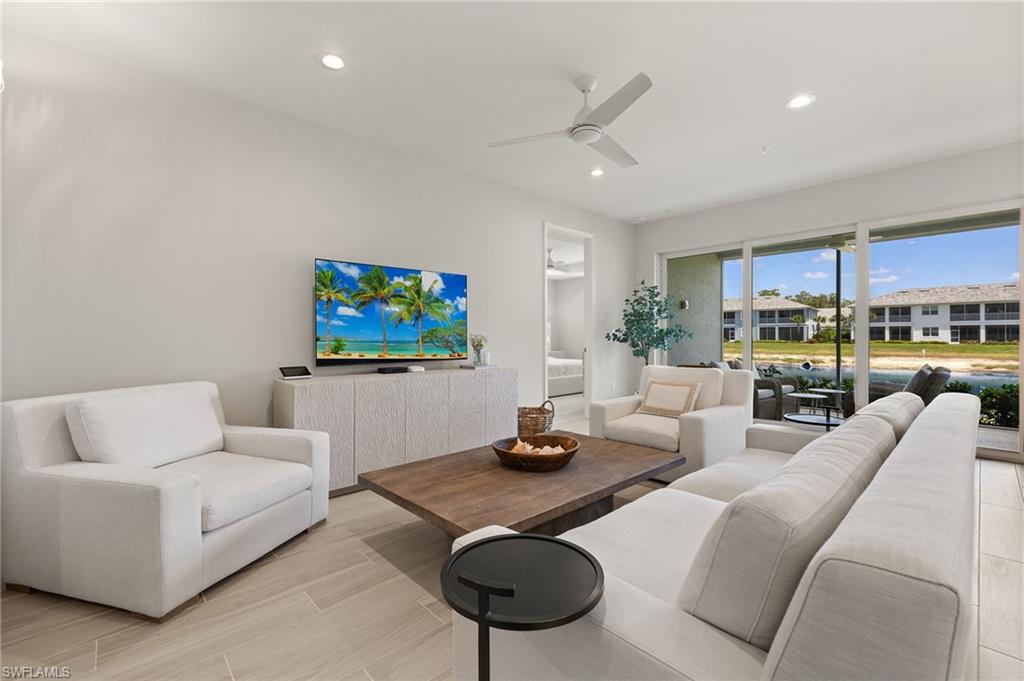 2647 Seychelles Circle, Unit 2203 Naples, FL 34112 - Photo 2 of 32 a living room with furniture a rug and a flat screen tv