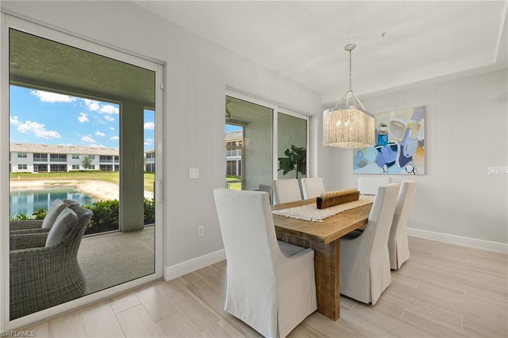 2647 Seychelles Circle, Unit 2203 Naples, FL 34112 - Photo 6 of 32 Dining area featuring baseboards, light wood-type flooring, and a chandelier