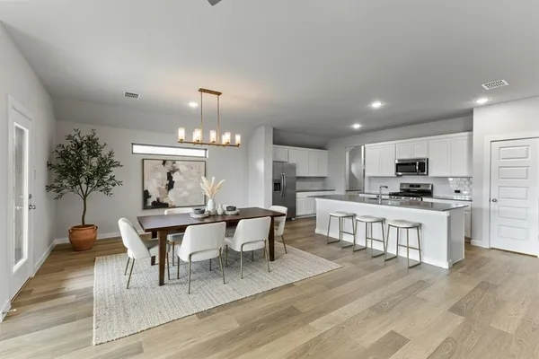 a view of a dining room with furniture and a kitchen