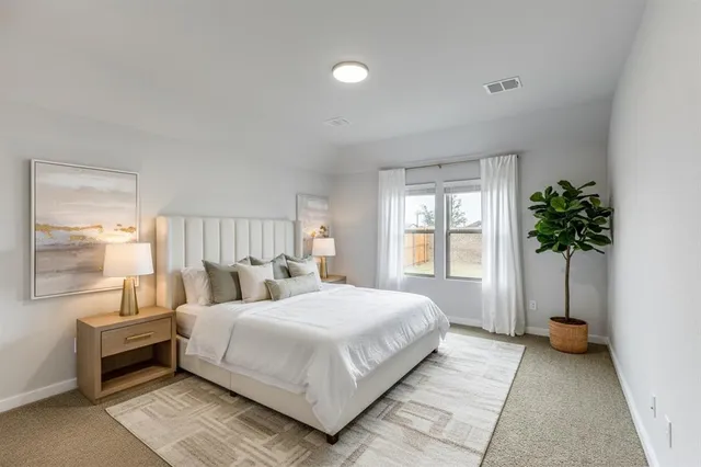 a bedroom with a large bed and a potted plant