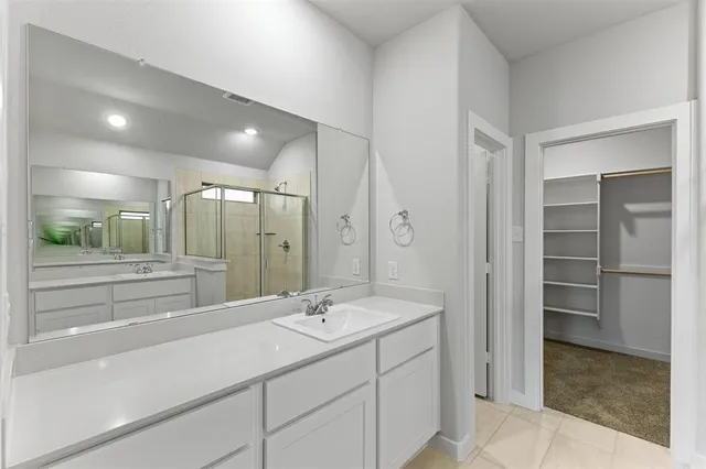 a bathroom with a double vanity sink mirror and shower