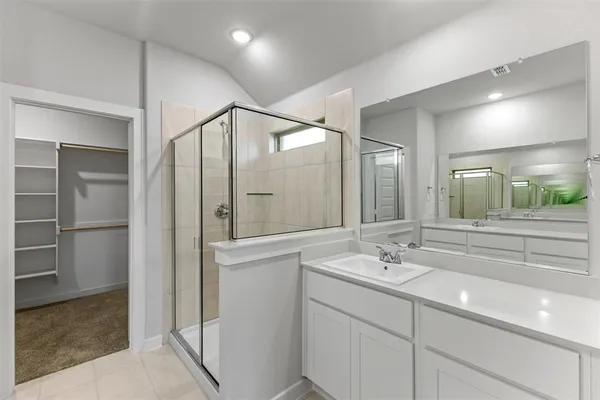 a bathroom with a shower sink and mirror