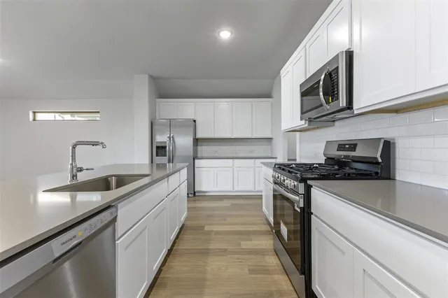 a kitchen with stainless steel appliances granite countertop a sink and a stove