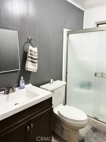 a bathroom with a sink a toilet a mirror and shower
