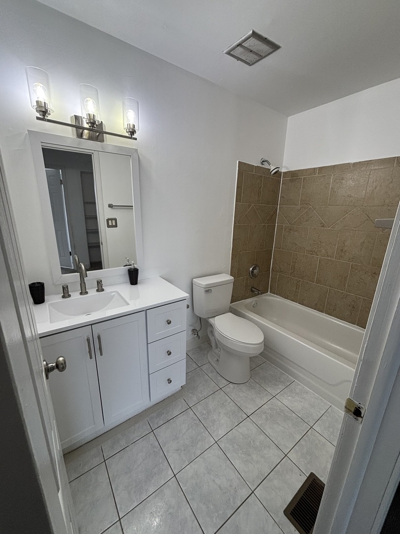 1707 Queensbury Circle Hoffman Estates, IL 60169 - Photo 6 of 10 a bathroom with a double vanity sink toilet and mirror