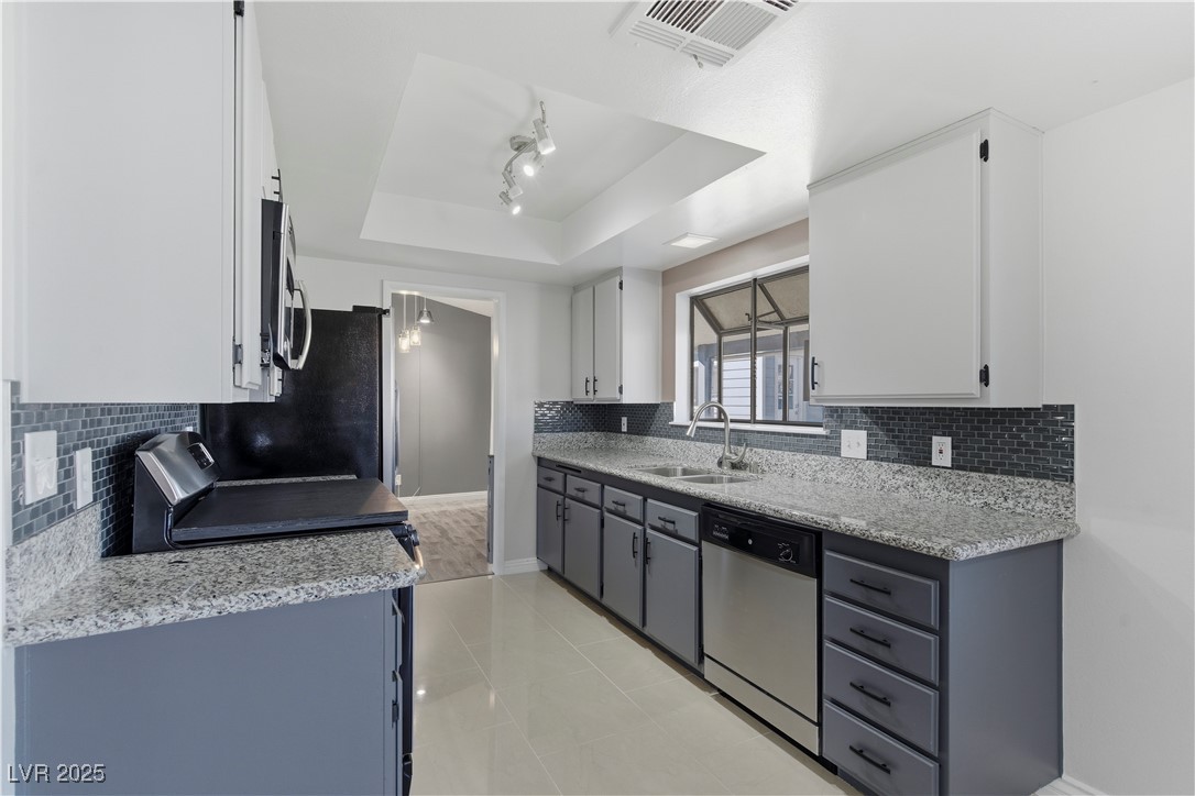 782 Darlene Way Boulder City, NV 89005 - Photo 11 of 39 Kitchen featuring decorative backsplash, gray cabinetry, and light stone counters