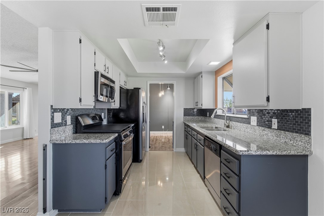 782 Darlene Way Boulder City, NV 89005 - Photo 12 of 39 Kitchen with light stone counters, stainless steel appliances, and white cabinets
