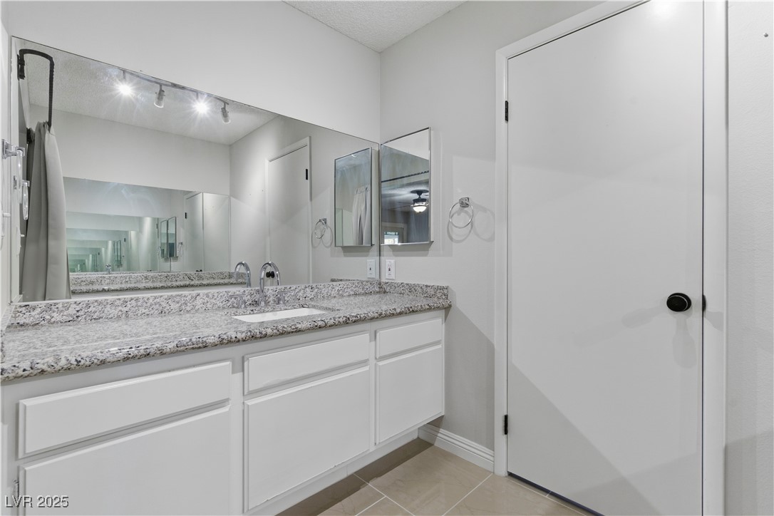 782 Darlene Way Boulder City, NV 89005 - Photo 19 of 39 Full bathroom featuring light tile patterned flooring, vanity, a textured ceiling, and rail lighting
