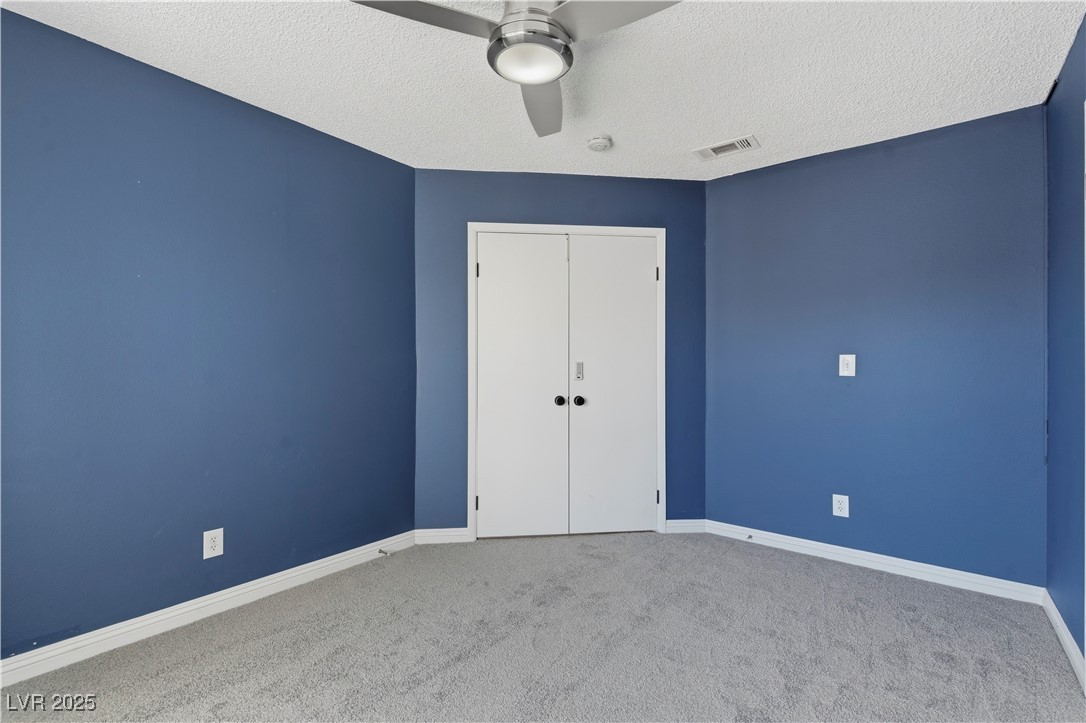 782 Darlene Way Boulder City, NV 89005 - Photo 21 of 39 Unfurnished bedroom featuring a textured ceiling, carpet floors, a closet, and a ceiling fan