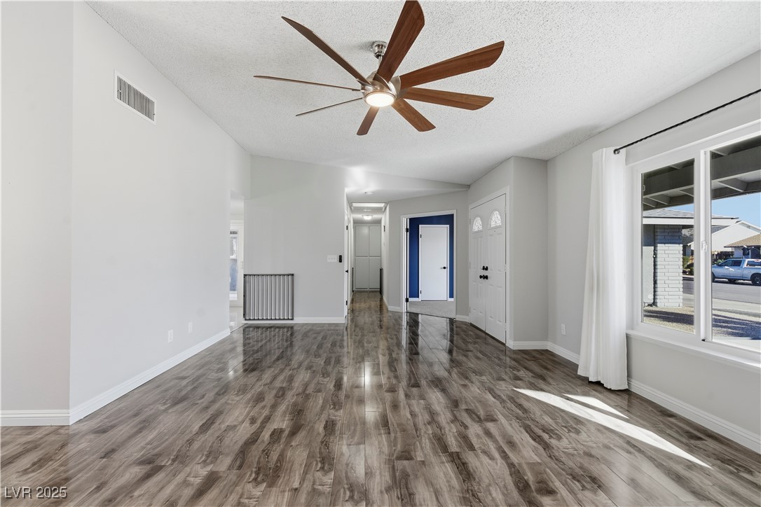 782 Darlene Way Boulder City, NV 89005 - Photo 6 of 39 Unfurnished living room featuring a textured ceiling, a ceiling fan, lofted ceiling, and wood finished floors